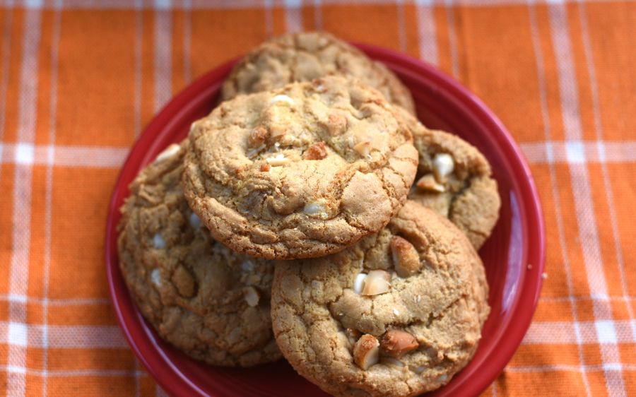 White chocolate macadamia cookies piled on a red plate
