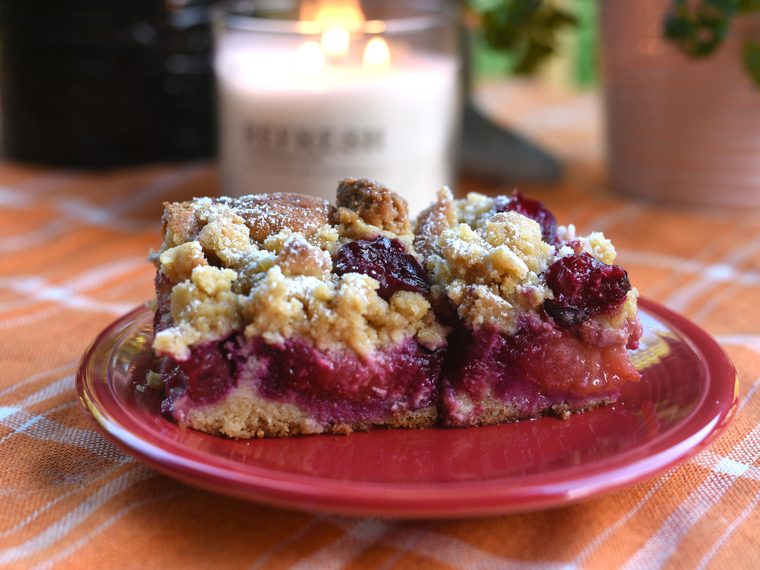 A slice of plum crumb cake dusted with sugar