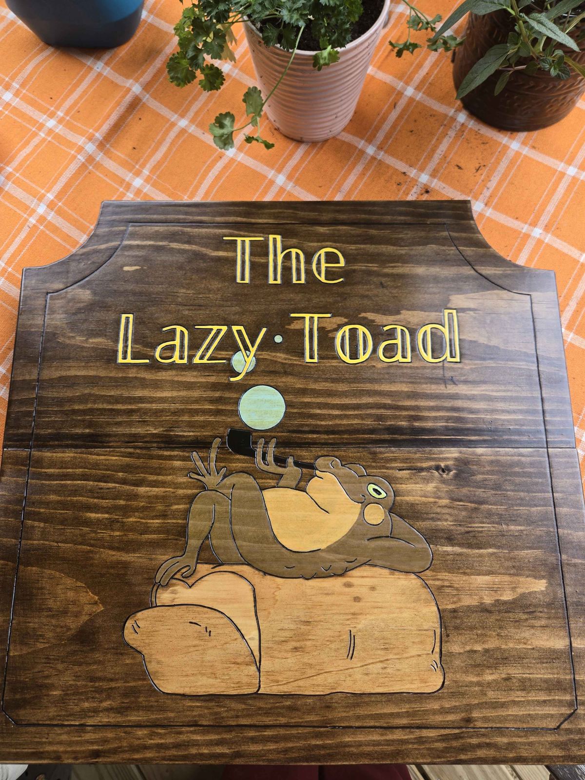 Hand-carved wooden sign for The Lazy Toad